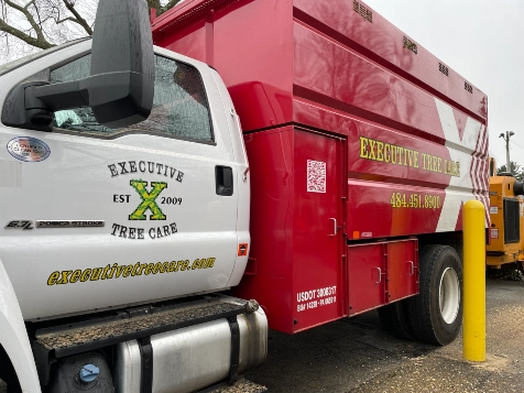 A clean, white and red Executive Tree Care service truck parked on-site, displaying the company logo and contact information, ready to assist homeowners in Lafayette Hill.